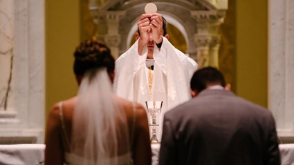 Casal no altar durante a missa